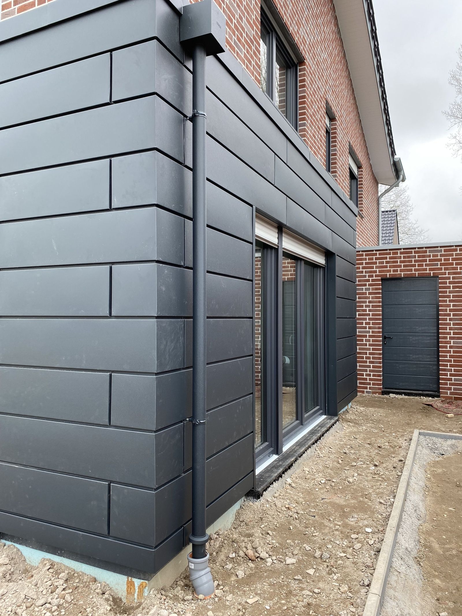 Graue Hausfassade mit Terrassentür